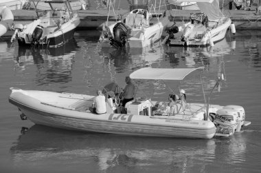 İtalya, Sicilya, Akdeniz, Marina di Ragusa (Ragusa ili); 13 Ağustos 2023, limandaki kauçuk bir teknede insanlar - EDITORIAL