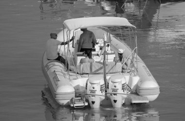 İtalya, Sicilya, Akdeniz, Marina di Ragusa (Ragusa ili); 13 Ağustos 2023, limandaki kauçuk bir teknede insanlar - EDITORIAL