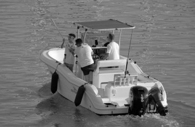 İtalya, Sicilya, Akdeniz, Marina di Ragusa (Ragusa ili); 13 Ağustos 2023, limandaki bir motorlu teknede balıkçı - EDITORIAL