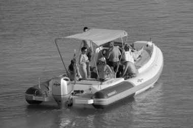 İtalya, Sicilya, Akdeniz, Marina di Ragusa (Ragusa ili); 13 Ağustos 2023, limandaki kauçuk bir teknede insanlar - EDITORIAL