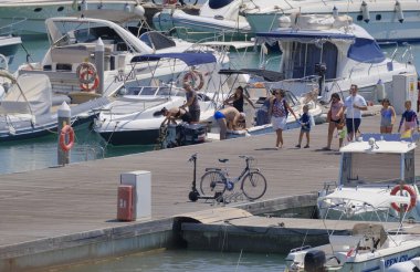 İtalya, Sicilya, Akdeniz, Marina di Ragusa (Ragusa ili); 15 Ağustos 2023, limandaki insanlar, motorlu tekneler ve lüks yatlar - EDITORIAL