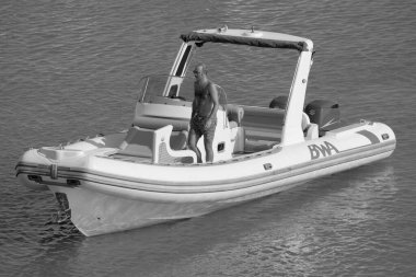 İtalya, Sicilya, Akdeniz, Marina di Ragusa (Ragusa ili); 18 Ağustos 2023, limandaki kauçuk bir teknede adam - EDITORIAL