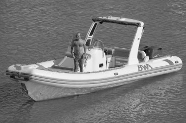 İtalya, Sicilya, Akdeniz, Marina di Ragusa (Ragusa ili); 18 Ağustos 2023, limandaki kauçuk bir teknede adam - EDITORIAL