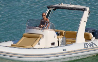 İtalya, Sicilya, Akdeniz, Marina di Ragusa (Ragusa ili); 18 Ağustos 2023, limandaki kauçuk bir teknede adam - EDITORIAL