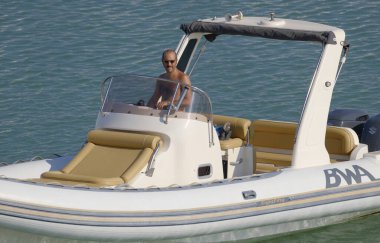 İtalya, Sicilya, Akdeniz, Marina di Ragusa (Ragusa ili); 18 Ağustos 2023, limandaki kauçuk bir teknede adam - EDITORIAL