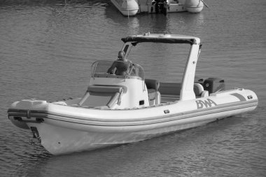 İtalya, Sicilya, Akdeniz, Marina di Ragusa (Ragusa ili); 18 Ağustos 2023, limandaki kauçuk bir teknede adam - EDITORIAL