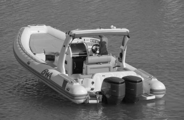 İtalya, Sicilya, Akdeniz, Marina di Ragusa (Ragusa ili); 18 Ağustos 2023, limandaki kauçuk bir teknede adam - EDITORIAL