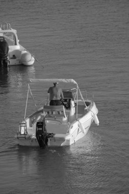 İtalya, Sicilya, Akdeniz, Marina di Ragusa (Ragusa ili); 18 Ağustos 2023, limandaki bir motorlu teknede adam - EDITORIAL