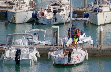 İtalya, Sicilya, Akdeniz, Marina di Ragusa (Ragusa ili); 19 Ağustos 2023, limandaki insanlar, motorlu tekneler ve lüks yatlar - EDITORIAL