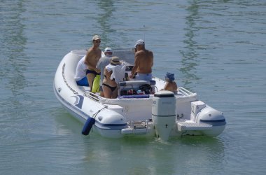 İtalya, Sicilya, Akdeniz, Marina di Ragusa (Ragusa ili); 20 Ağustos 2023, limandaki kauçuk bir teknede insanlar - EDITORIAL