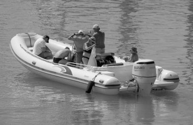 İtalya, Sicilya, Akdeniz, Marina di Ragusa (Ragusa ili); 20 Ağustos 2023, limandaki kauçuk bir teknede insanlar - EDITORIAL