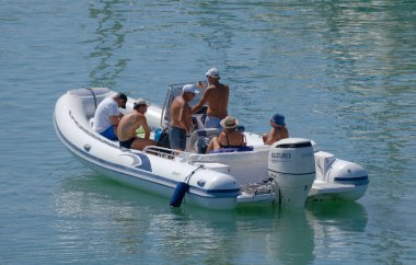 İtalya, Sicilya, Akdeniz, Marina di Ragusa (Ragusa ili); 20 Ağustos 2023, limandaki kauçuk bir teknede insanlar - EDITORIAL