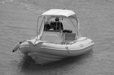 İtalya, Sicilya, Akdeniz, Marina di Ragusa (Ragusa Eyaleti); 26 Ağustos 2023, limandaki bir lastik teknede adam - EDITORIAL