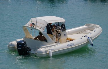İtalya, Sicilya, Akdeniz, Marina di Ragusa (Ragusa ili); 26 Ağustos 2023, limanda kauçuk bir tekne ve lüks yatlarda bir çift - EDITORIAL