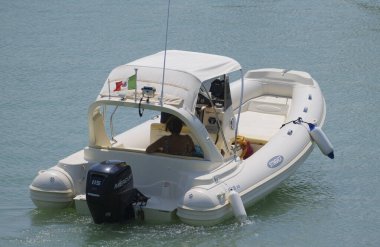 İtalya, Sicilya, Akdeniz, Marina di Ragusa (Ragusa ili); 26 Ağustos 2023, limanda kauçuk bir tekne ve lüks yatlarda bir çift - EDITORIAL