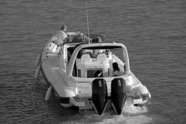 İtalya, Sicilya, Akdeniz, Marina di Ragusa (Ragusa Eyaleti); 1 Eylül 2023, limandaki büyük bir kauçuk teknede köpekli kadınlar - EDITORIAL