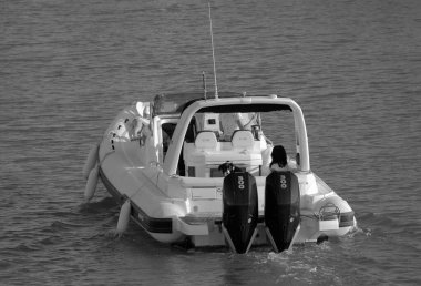 İtalya, Sicilya, Akdeniz, Marina di Ragusa (Ragusa Eyaleti); 1 Eylül 2023, limandaki büyük bir kauçuk teknede köpekli kadınlar - EDITORIAL