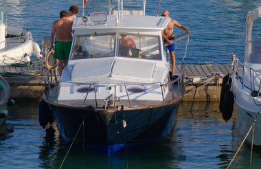 İtalya, Sicilya, Akdeniz, Marina di Ragusa (Ragusa Eyaleti), limanda lüks bir yatta yaşayan insanlar. 