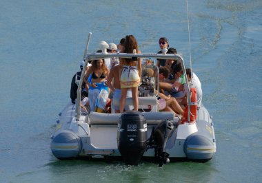 İtalya, Sicilya, Akdeniz, Marina di Ragusa (Ragusa Eyaleti); 3 Eylül 2023, limandaki kauçuk bir teknede insanlar - EDITORIAL