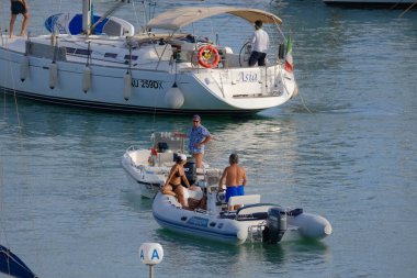 İtalya, Sicilya, Akdeniz, Marina di Ragusa (Ragusa Eyaleti); 3 Eylül 2023, limandaki motorlu tekneler ve lüks yatlarda yaşayan insanlar - EDITORIAL