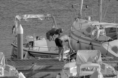 İtalya, Sicilya, Akdeniz, Marina di Ragusa (Ragusa ili); 13 Eylül 2023, limandaki insanlar, motorlu tekneler ve lüks yatlar - EDITORIAL