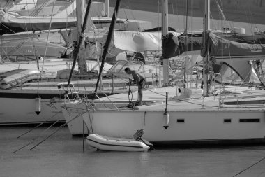 İtalya, Sicilya, Akdeniz, Marina di Ragusa (Ragusa Eyaleti); 14 Eylül 2023, limandaki bir yelkenli teknesinde adam - EDITORIAL