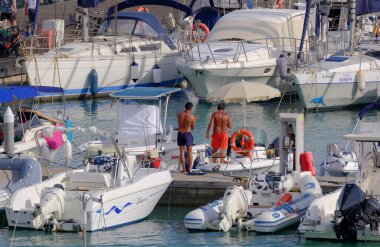 İtalya, Sicilya, Akdeniz, Marina di Ragusa (Ragusa Eyaleti); 16 Eylül 2023, limanda halk, motorlu tekneler ve lüks yatlar - EDITORIAL