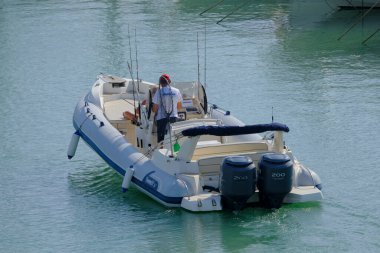 İtalya, Sicilya, Akdeniz, Marina di Ragusa (Ragusa ili); 7 Ekim 2023, limanda büyük bir kauçuk teknede çift - EDITORIAL