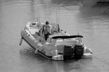 İtalya, Sicilya, Akdeniz, Marina di Ragusa (Ragusa ili); 7 Ekim 2023, limanda büyük bir kauçuk teknede çift - EDITORIAL