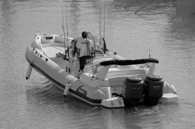 İtalya, Sicilya, Akdeniz, Marina di Ragusa (Ragusa ili); 7 Ekim 2023, limanda büyük bir kauçuk teknede çift - EDITORIAL