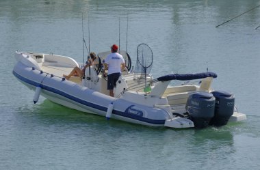 İtalya, Sicilya, Akdeniz, Marina di Ragusa (Ragusa ili); 7 Ekim 2023, limanda büyük bir kauçuk teknede çift - EDITORIAL