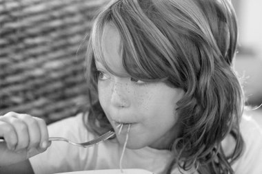 İtalya, Sicilya; 7 yaşında erkek çocuk domates soslu spagetti yiyor.