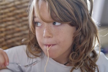 İtalya, Sicilya; 7 yaşında erkek çocuk domates soslu spagetti yiyor.