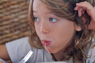 İtalya, Sicilya; 7 yaşında erkek çocuk domates soslu spagetti yiyor.