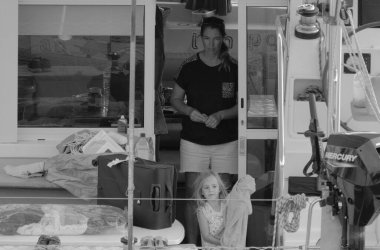 İtalya, Sicilya, Akdeniz, Marina di Ragusa (Ragusa Eyaleti); 11 Kasım 2023, limandaki katamaran yelkenli teknesindeki insanlar - EDITORIAL