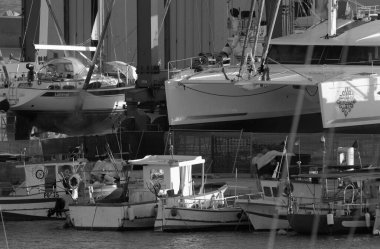 İtalya, Sicilya, Marina di Ragusa (Ragusa Eyaleti), 13 Kasım 2023, limanda yerel balıkçı tekneleri ve lüks yatlar - EDITORIAL