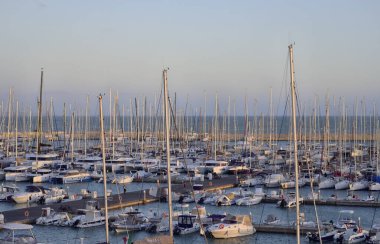 İtalya, Sicilya, Akdeniz, Marina di Ragusa (Ragusa ili); 17 Kasım 2023, gün batımında limanda motorlu tekne ve lüks yatlar - EDITORIAL