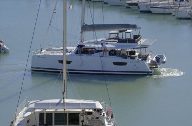 İtalya, Sicilya, Akdeniz, Marina di Ragusa (Ragusa Eyaleti); 19 Kasım 2023, limandaki bir katamaran yelkenli teknesinde erkekler - EDITORIAL