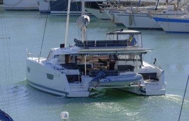 İtalya, Sicilya, Akdeniz, Marina di Ragusa (Ragusa Eyaleti); 19 Kasım 2023, limandaki bir katamaran yelkenli teknesinde erkekler - EDITORIAL