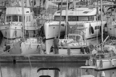 İtalya, Sicilya, Akdeniz, Marina di Ragusa (Ragusa Eyaleti); 7 Aralık 2023, limandaki insanlar ve lüks yatlar - EDITORIAL