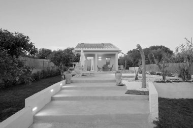 İtalya, Sicilya, Ragusa Eyaleti, kırsal kesim; 30 Mart 2023, zarif özel ev, yüzme havuzu manzarası ve gün batımında bahçe - EDITORIAL