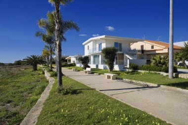 İtalya, Sicilya, Akdeniz, Playa Grande (Ragusa Eyaleti); deniz kenarında evler ve palmiye ağaçları 