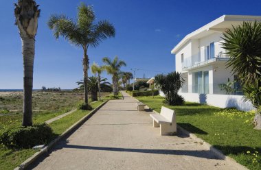 İtalya, Sicilya, Akdeniz, Playa Grande (Ragusa Eyaleti); deniz kenarında evler ve palmiye ağaçları 