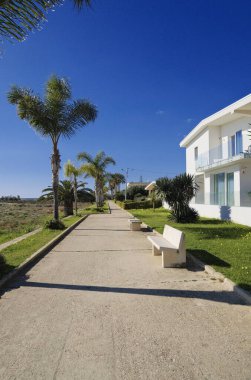 İtalya, Sicilya, Akdeniz, Playa Grande (Ragusa Eyaleti); deniz kenarında evler ve palmiye ağaçları 