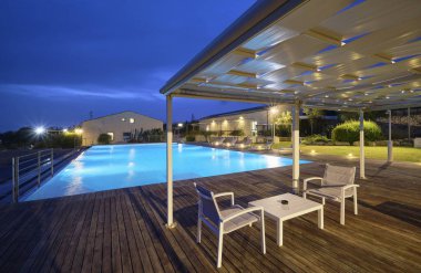 İtalya, Sicilya, Ragusa Eyaleti, kırsal kesim; 13 Nisan 2023, zarif bir çiftlik, gün batımında yüzme havuzu manzarası - EDITORIAL