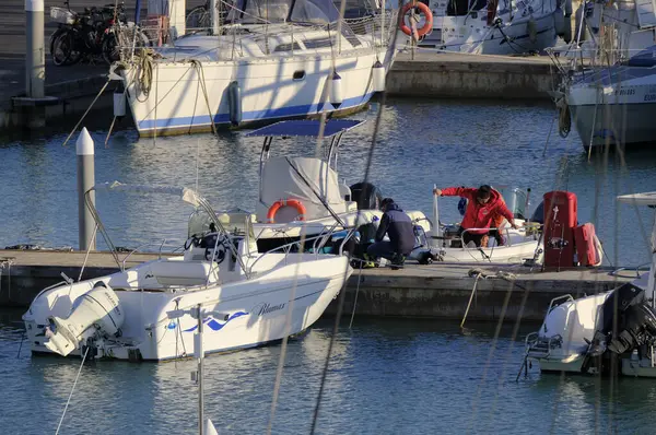 İtalya, Sicilya, Akdeniz, Marina di Ragusa (Ragusa Eyaleti); 3 Şubat 2024, limandaki bir motorlu teknede balıkçı - EDITORIAL