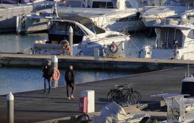 İtalya, Sicilya, Akdeniz, Marina di Ragusa (Ragusa Eyaleti); 6 Şubat 2024, limandaki insanlar ve lüks yatlar - EDITORIAL