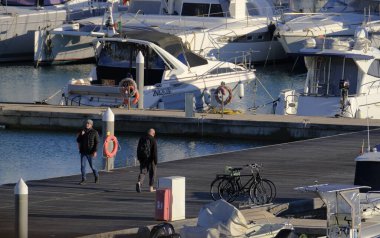 İtalya, Sicilya, Akdeniz, Marina di Ragusa (Ragusa Eyaleti); 6 Şubat 2024, limandaki insanlar ve lüks yatlar - EDITORIAL