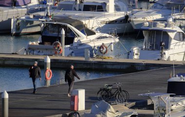 İtalya, Sicilya, Akdeniz, Marina di Ragusa (Ragusa Eyaleti); 6 Şubat 2024, limandaki insanlar ve lüks yatlar - EDITORIAL