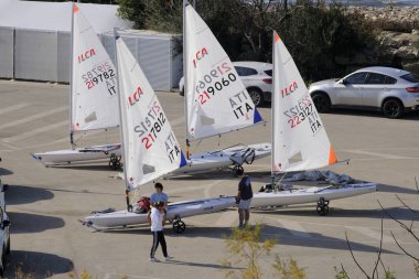 İtalya, Sicilya, Akdeniz, Marina di Ragusa; 9 Şubat 2024, limandaki insanlar ve yelkenliler - EDITORIAL